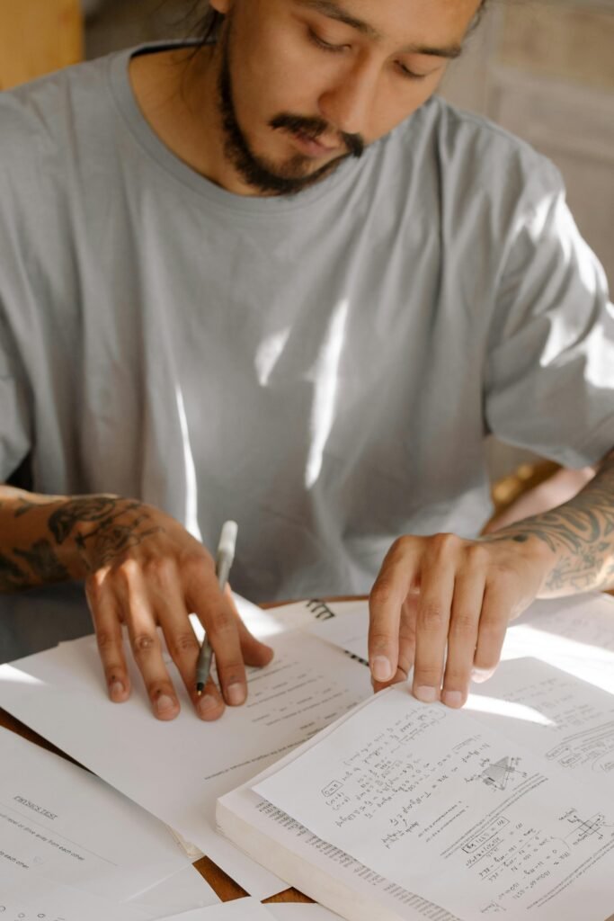 Man in White Crew Neck T-shirt Holding White Printer Paper