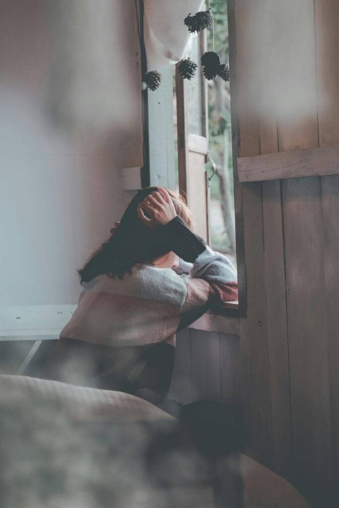 Photo of a Person Leaning on Wooden Window